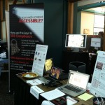 Our booth at IDEAS with poster about section 508 compliance and conference materials.