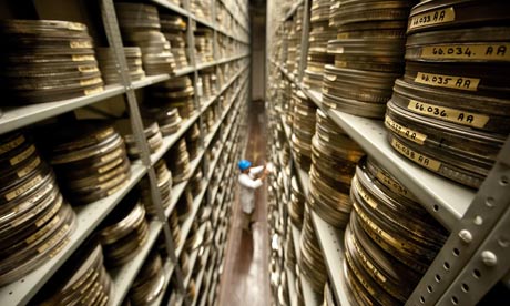 Sorting through tall shelves of film canisters.